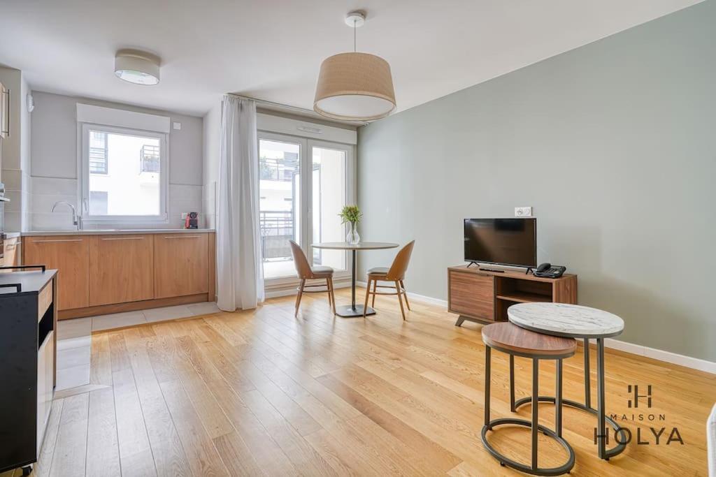 une cuisine et un salon avec une table et des chaises dans l'établissement Le Clairsemé - En bordure de Paris - 364B, à Issy-les-Moulineaux