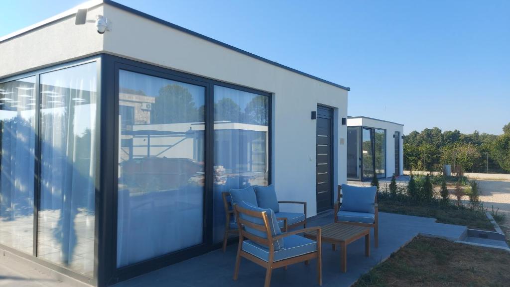 una casa con puertas de cristal y sillas en un patio en Casa Aurelia, en Gornji Štoj