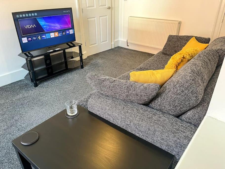 a living room with a couch and a flat screen tv at 8 Nantwich Road in Crewe