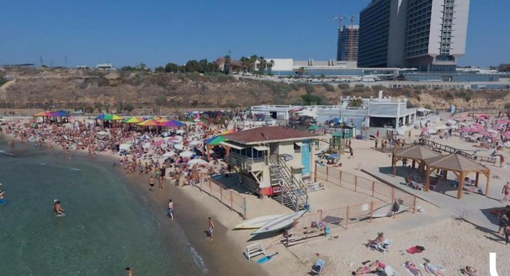 een luchtzicht op een strand met een menigte mensen bij Apartment near Hilton in Tel Aviv