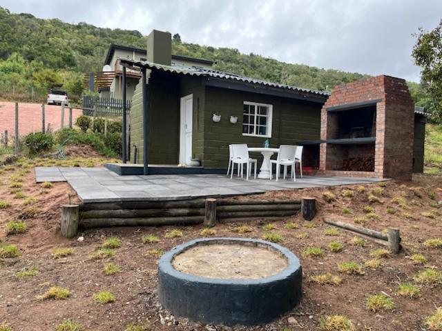 Casa pequeña con patio con sillas y mesa. en Rushmere Cottage, en Sedgefield