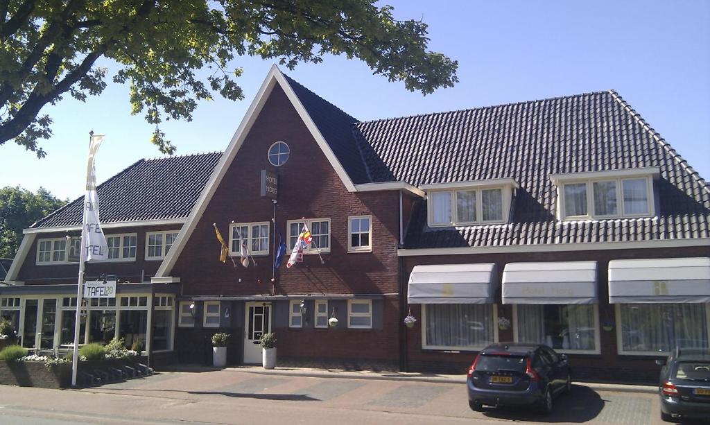 een groot bruin gebouw met een zwart dak bij Hotel Norg in Norg