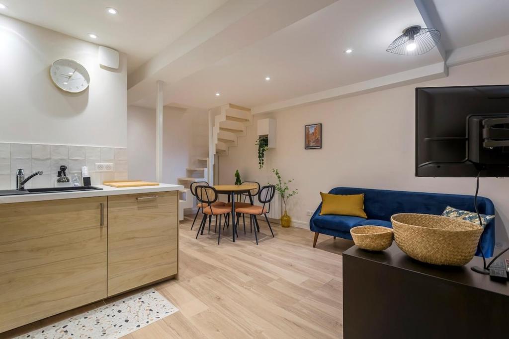 Il comprend une cuisine et un salon doté d'un canapé bleu. dans l'établissement Charming Duplex Nest Newly Renovated, à Lyon