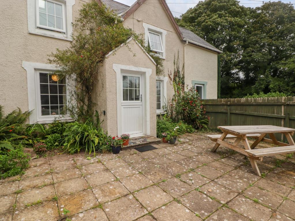 a backyard with a picnic table and a house at 2 Cheriton Cottages in Pembroke