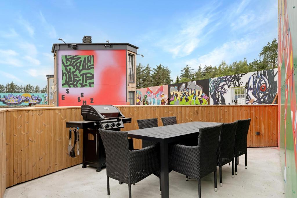a patio with a table and chairs and a grill at Family-Friendly Holiday Homes In Fun Art, Blokhus in Pandrup
