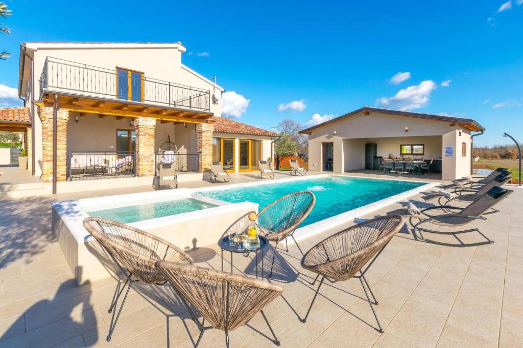 patio z krzesłami i basenem w obiekcie Relaxing pool villa Mattuzzi in Loborika w mieście Loborika