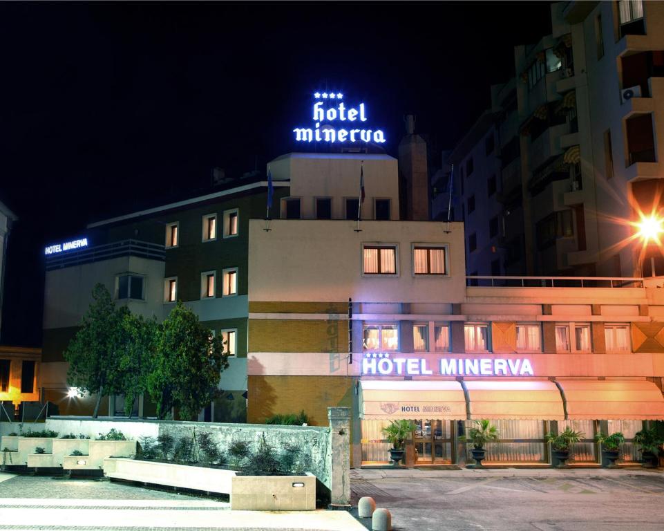 波代諾內的住宿－米內爾瓦酒店，一家晚上在上面标有标志的酒店