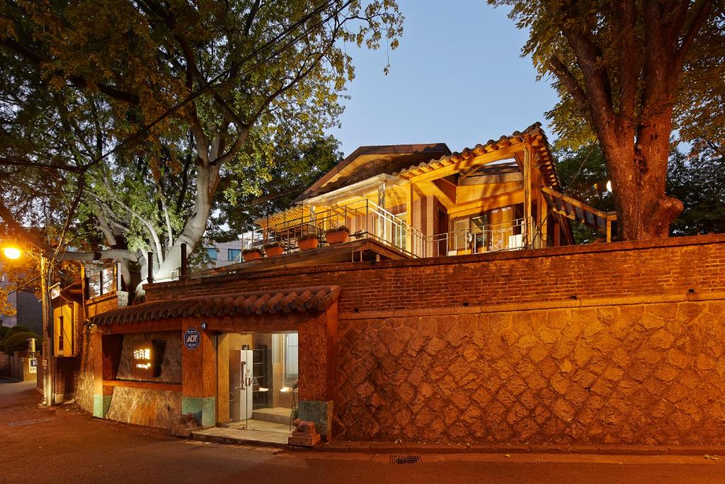 un bâtiment au-dessus d'un mur de briques dans l'établissement Jiwoljang Guesthouse, à Séoul