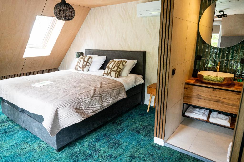 a bedroom with a large bed and a mirror at Boetiekhotel Het Huis in Fluitenberg