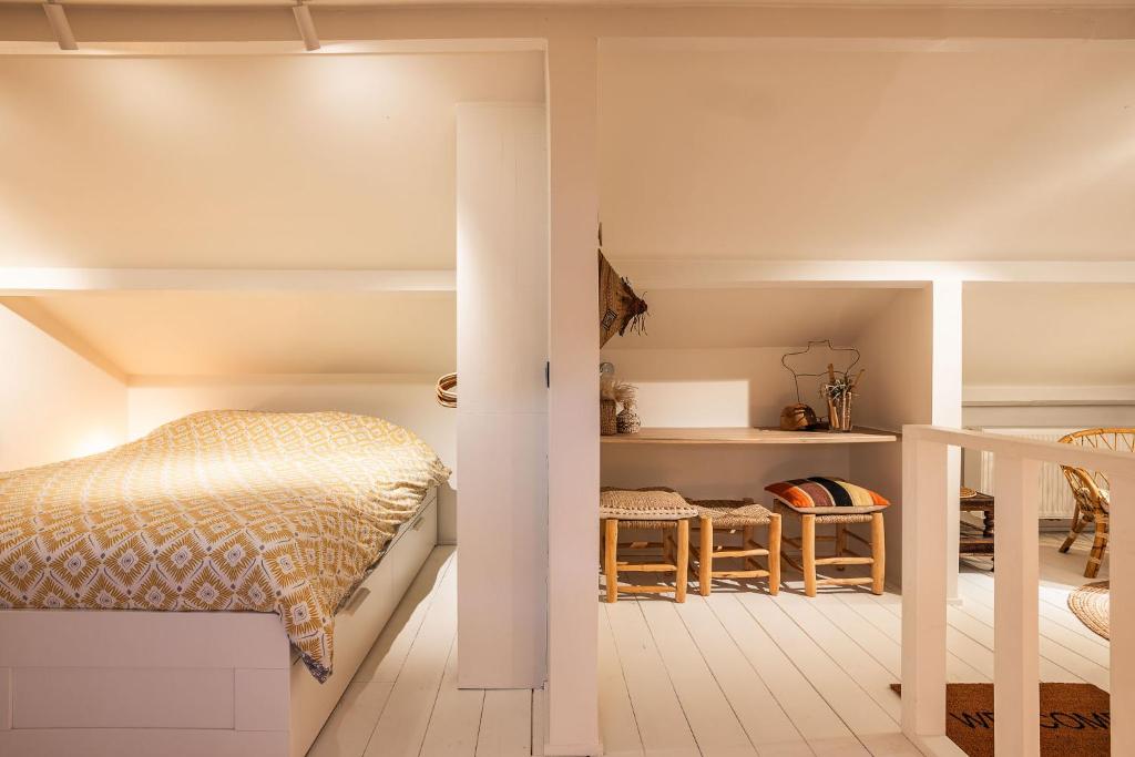 a small bedroom with a bed and a staircase at vakantiehuis Cerise, Luxueus genieten in de Leiestreek in Deinze