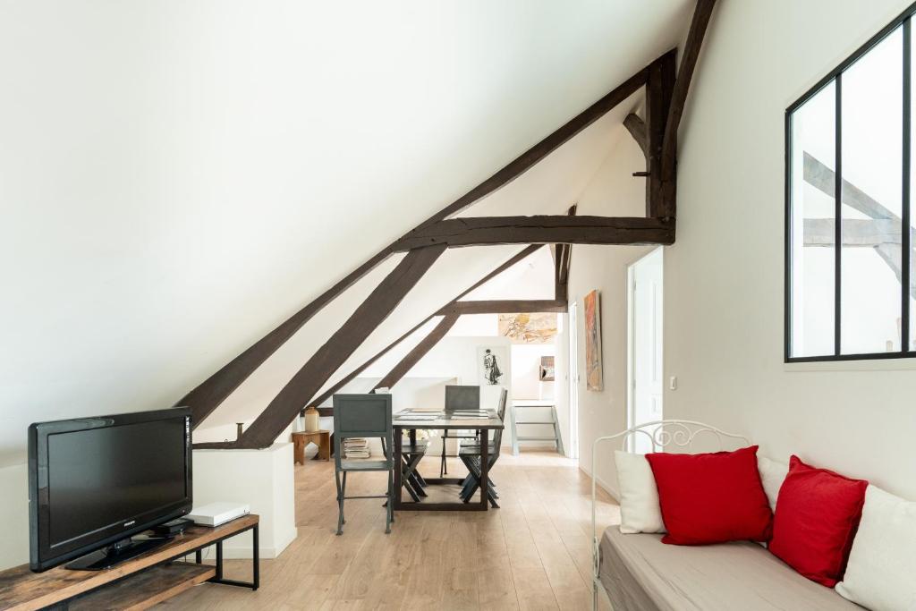 un salon avec un canapé et une télévision dans l'établissement Le comble du bonheur, à Cinqueux