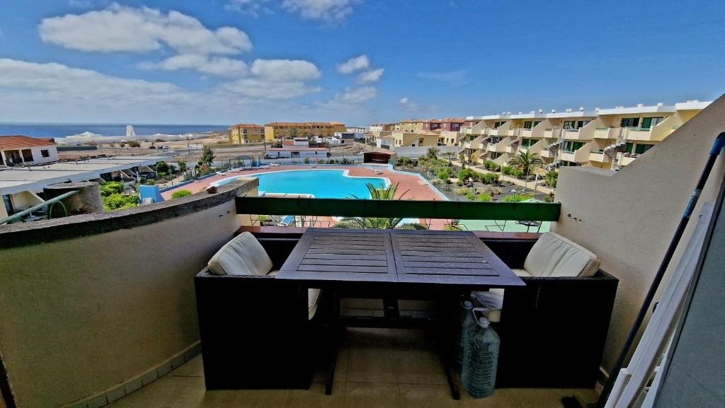 a balcony with a table and a swimming pool at Wind House in Costa de Antigua