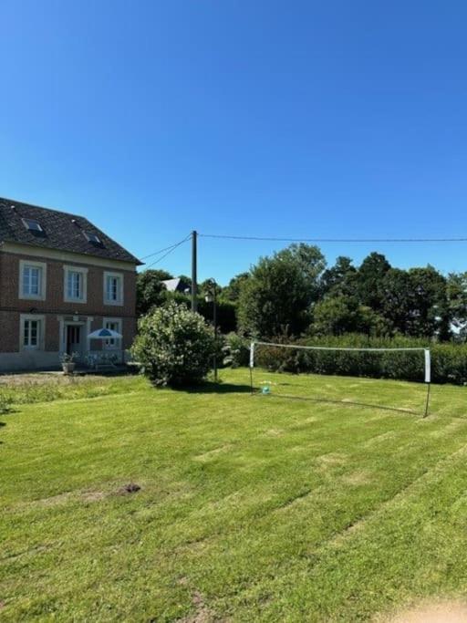 une cour avec une maison et un court de tennis dans l'établissement Maison campagne Normande, à Blacqueville