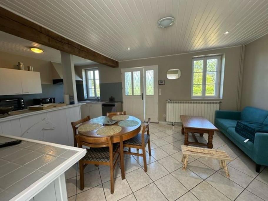 a kitchen and living room with a table and chairs at Maison campagne Normande in Blacqueville
