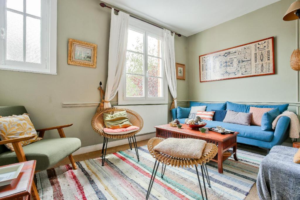 un salon avec un canapé bleu et des chaises dans l'établissement 50m de la plage du Prieuré - Maison de ville pour 6, à Dinard