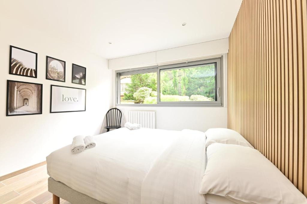 une chambre blanche avec un lit et une fenêtre dans l'établissement Appartement Climatisé Porte Versailles, à Paris
