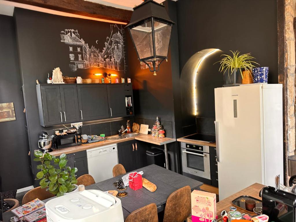 une cuisine avec une table et un réfrigérateur blanc dans l'établissement Charme&caractère, à Dijon