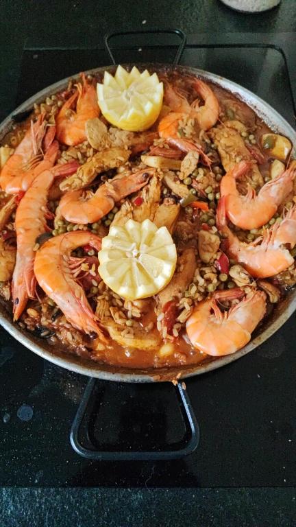 a pan of food with shrimp and lemon slices at Chambre au coeur des vignes in Myans