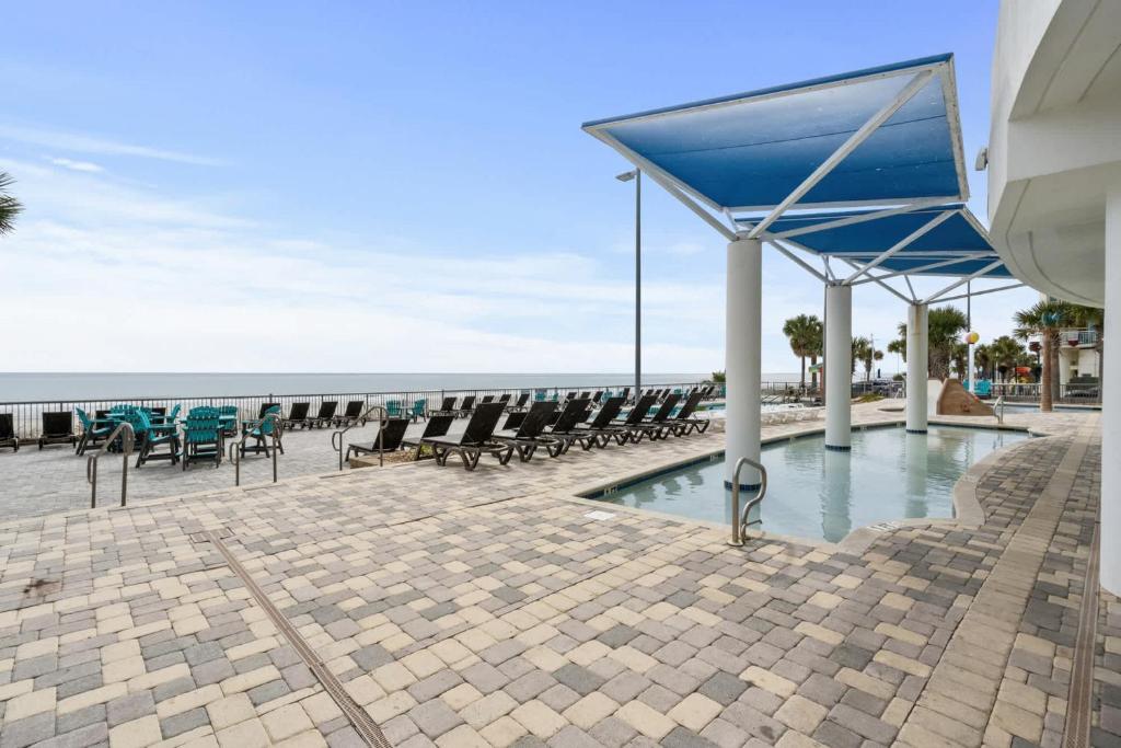 a group of chairs and tables on the beach at Oceans One Resort Unit 404 - Oceanfront in Myrtle Beach
