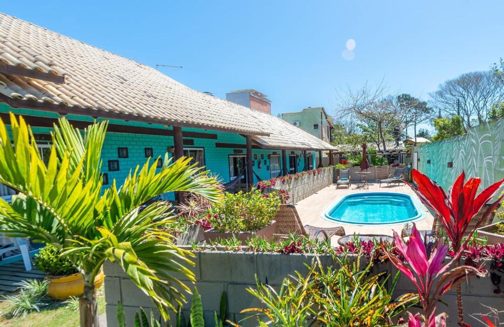 a house with a swimming pool in the yard at Pousada Hanalie by Easy Hotéis in Praia do Rosa