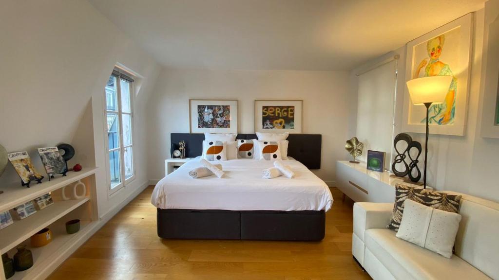 une chambre avec un grand lit et un canapé dans l'établissement Pompidou, rue Simon le Franc - 4 places, à Paris