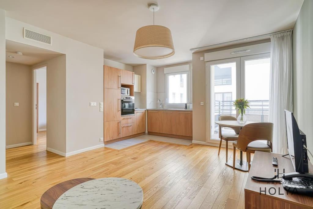 un salon avec une table et une cuisine dans l'établissement Le Spacieux - En bordure de Paris - 366B, à Issy-les-Moulineaux