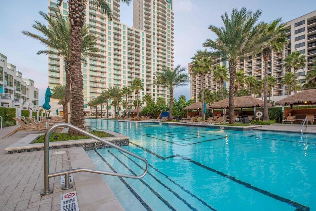 Una gran piscina con palmeras y edificios. en 1801 Sapphire Beachfront 3 Bedroom Condo, en South Padre Island