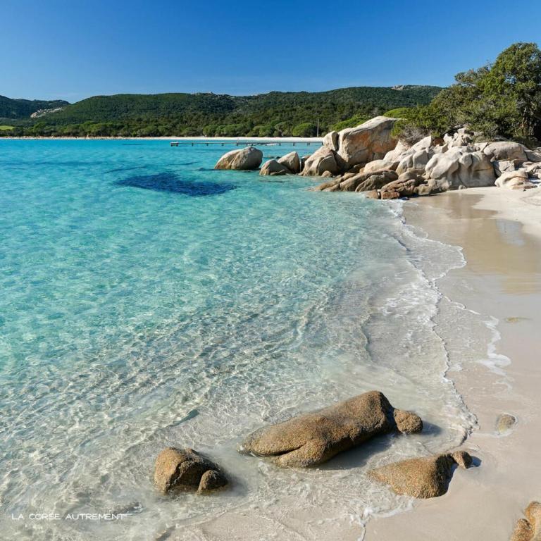 une plage avec des rochers dans l'eau dans l'établissement E Casette Di Santa Giulia, à Porto-Vecchio