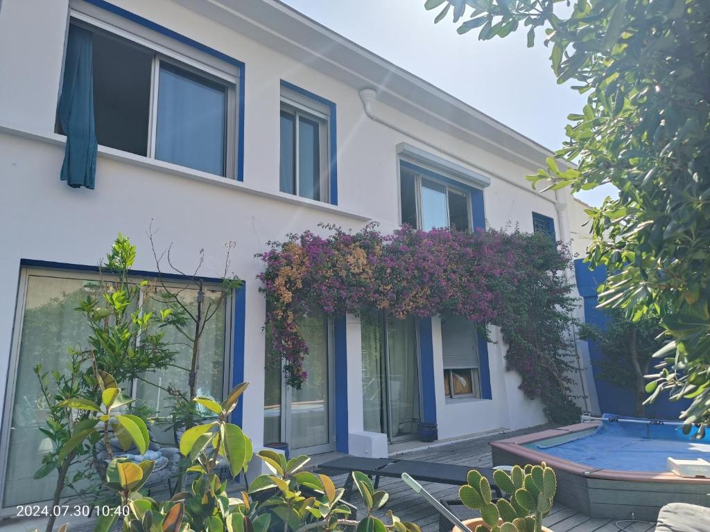 une maison avec des fleurs violettes sur son côté dans l'établissement Appartement au cœur des Calanques, à Marseille