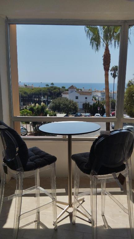 a table and two chairs in front of a window at Sea View Calypso Condo in Mijas