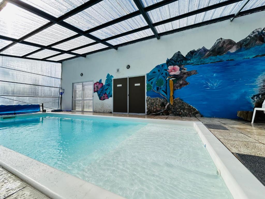 a swimming pool with a mural on the wall at Cabañas Quijote in Lago Puelo