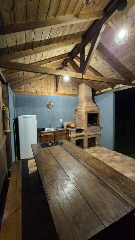 a kitchen with a large wooden table in a room at Pousada Recanto das Araucárias in Urubici