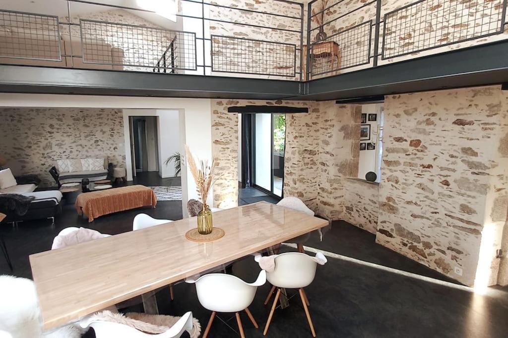 Una sala de estar con una mesa y sillas de madera. en Gite le Parveau, 3 étoiles meublé de tourisme, en La Guiltière