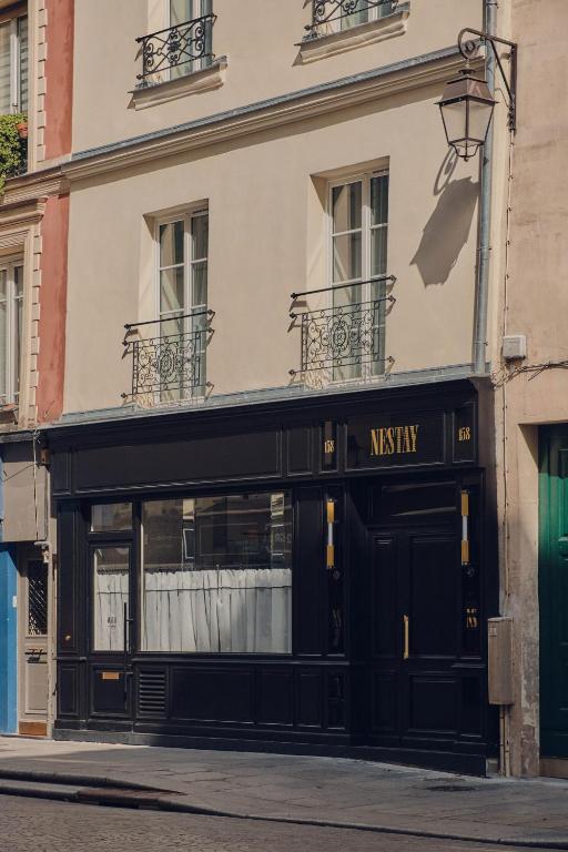 un magasin devant un bâtiment avec un panneau indiquant un musée dans l'établissement Nestay Sentier, à Paris