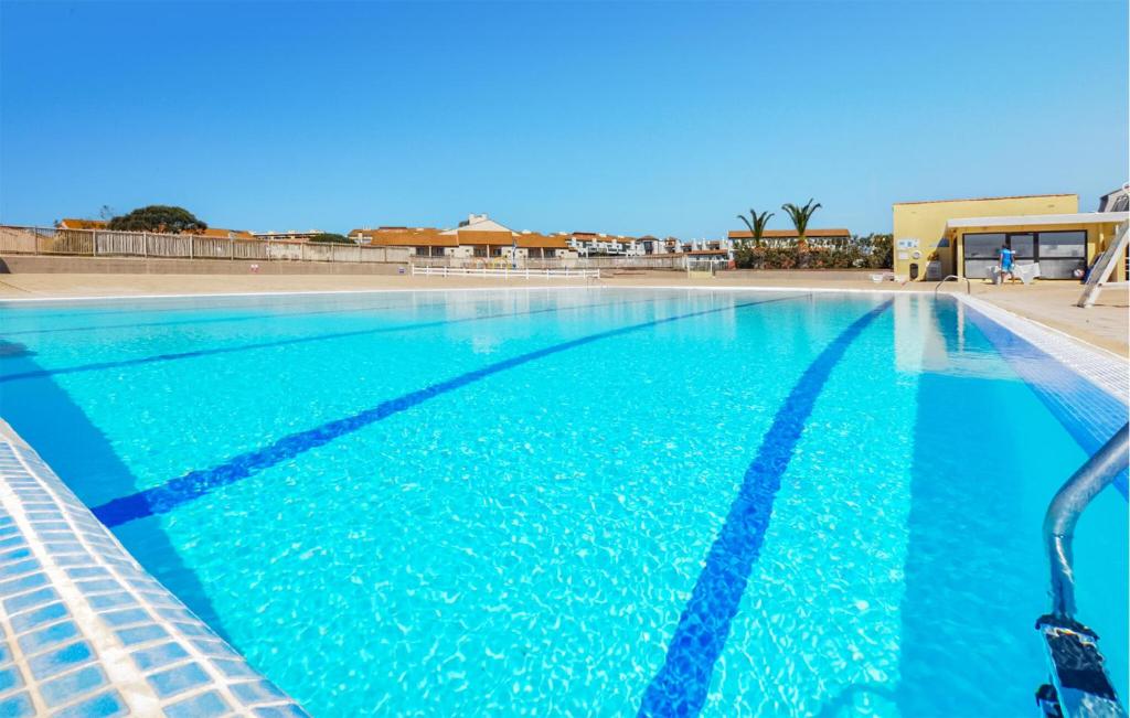 une grande piscine avec de l'eau bleue dans l'établissement Beautiful Apartment In Le Barcarès, au Barcarès
