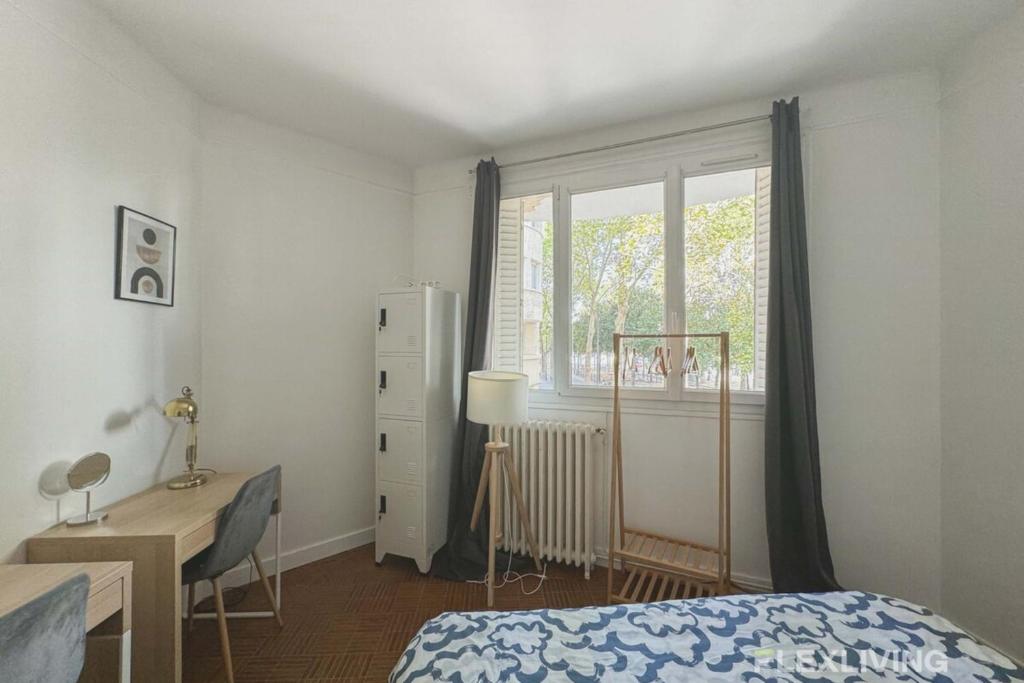 une chambre avec un lit, un bureau et une fenêtre dans l'établissement Flexliving - room - Verdun, à Paris