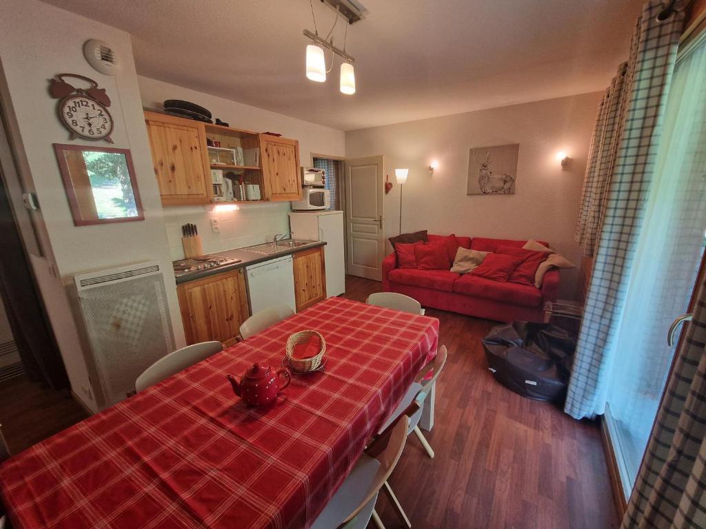 un salon avec une table et un canapé rouge dans l'établissement Appartement 3 pièces pour 6 pers, proche télécabine et commerces à Modane - FR-1-265-228, à Valfréjus