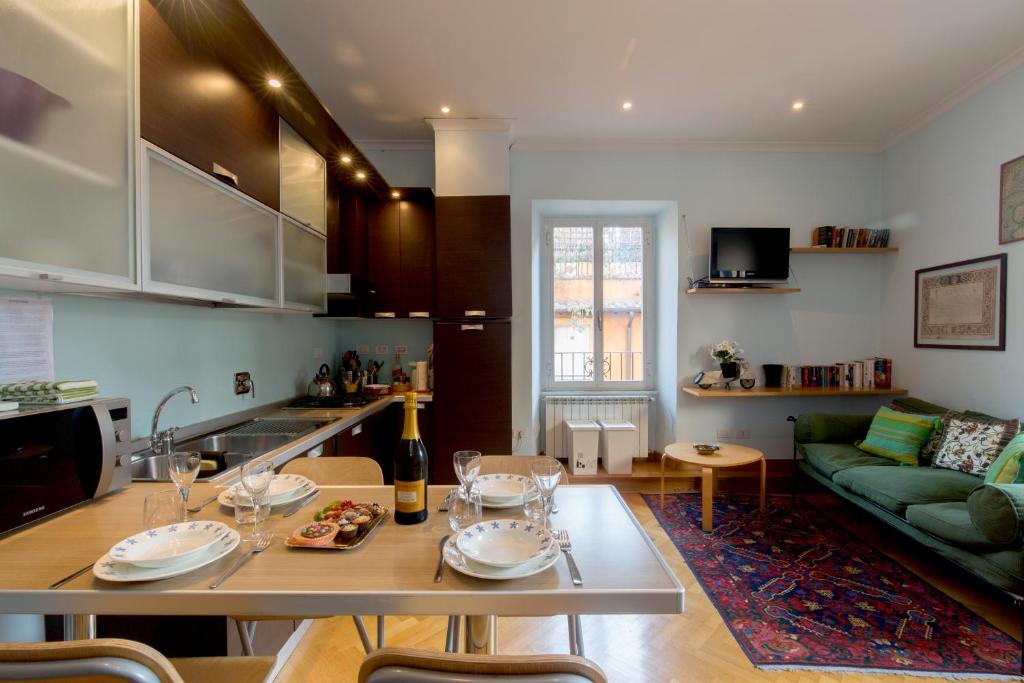 a kitchen and living room with a table and a couch at Holidays Banchi Vecchi Apartment in Rome