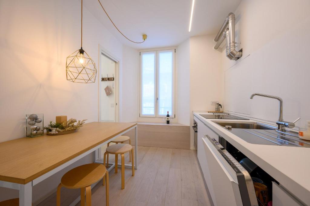 a kitchen with a sink and a counter with stools at Appartamento Garibaldi in Morbegno