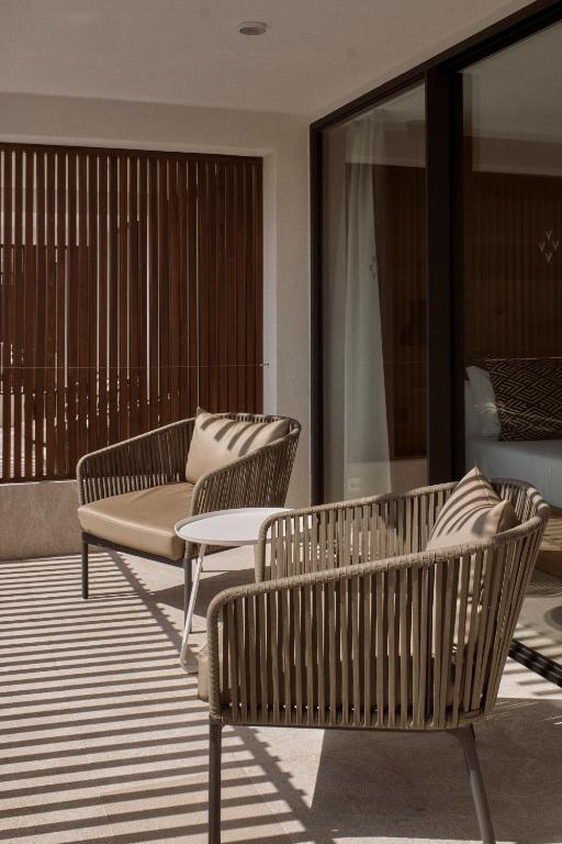 a group of chairs sitting on a balcony at Las Gaviotas Suites Hotel & Spa in Playa de Muro