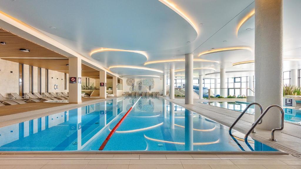 a large swimming pool in a large building at Apartamenty Tukan- Polanki Aqua - Holiday City in Kołobrzeg