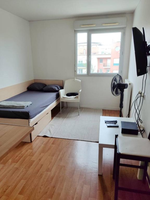 une chambre avec un lit, un bureau et une fenêtre dans l'établissement logement calme proche de paris, à Créteil