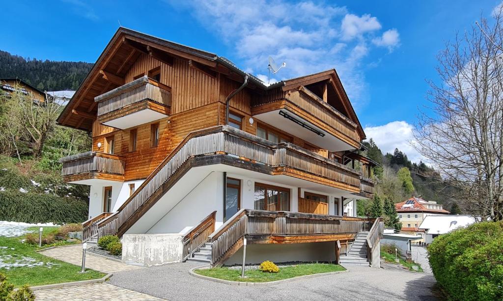 una casa con balcones de madera en un lateral en Haus Margaret By Globalimmoservice, en Bad Kleinkirchheim