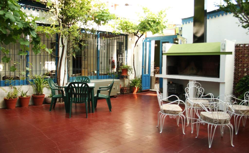 un patio con mesa, sillas y chimenea en Antonieta Hostel en San Rafael