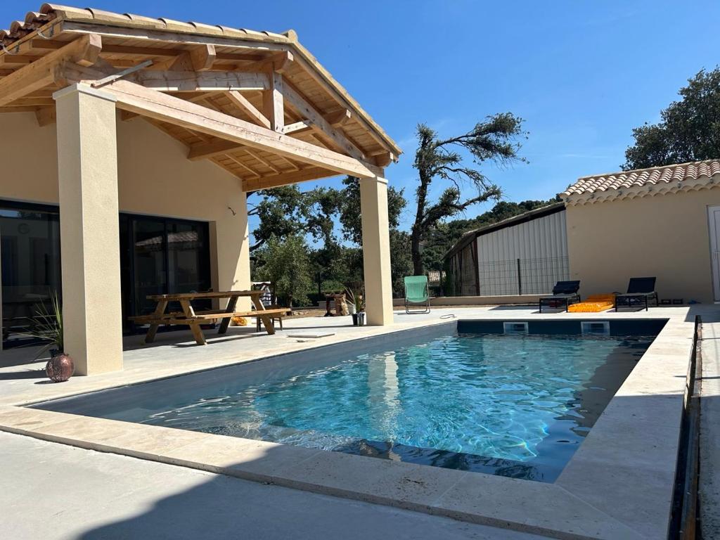 een patio met een zwembad en een houten pergola bij Maison Les Chênes d'Hélios en Drôme provençale in Réauville