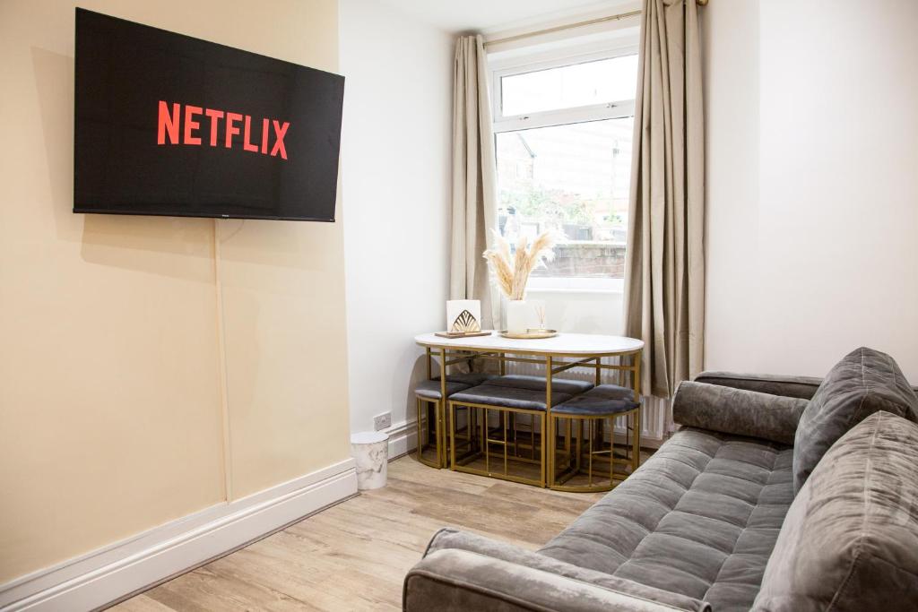 a living room with a couch and a table at Entire Luxury Home in Old Trafford, next to MUFC in Manchester