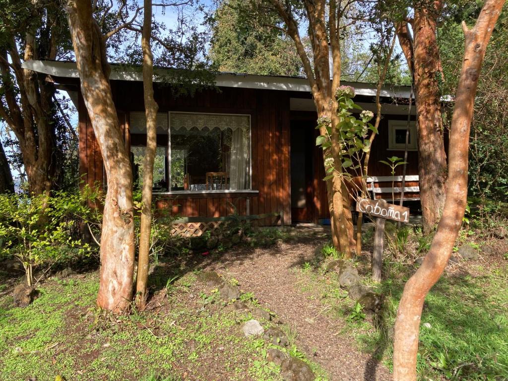 a cabin in the woods with a sign in front of it at Cabañas el Bosque Patagónico in Frutillar