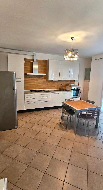 a kitchen with a table and a dining room at APPARTAMENTO A DUE PASSI DAL MARE By VILLA FIORITA in Cattolica