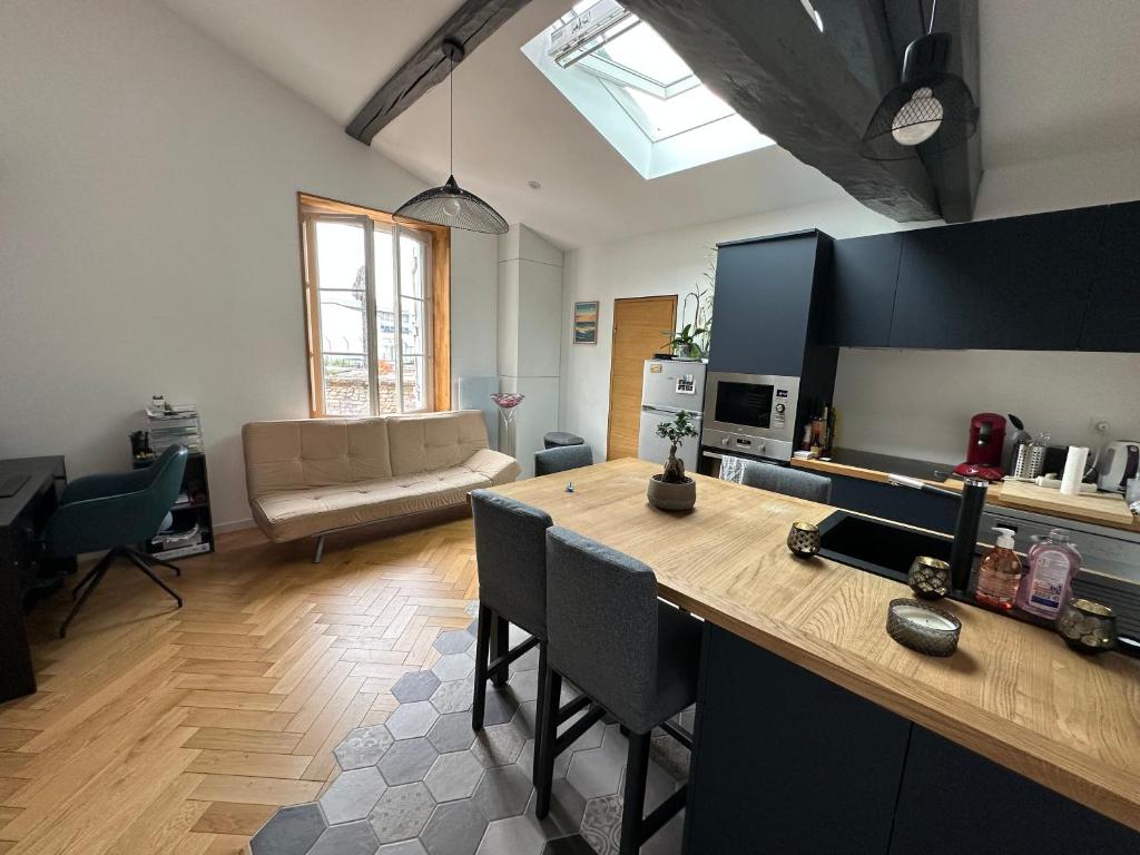 une cuisine et un salon avec une table et des chaises dans l'établissement L appartement canal du midi, à Toulouse