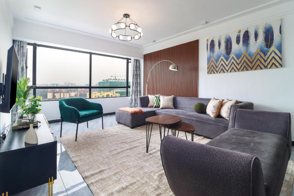un salon avec un canapé et une table dans l'établissement Nyumbani Oasis - Tastefully Furnished Three Bedroom Apartment In Kilimani, à Nairobi